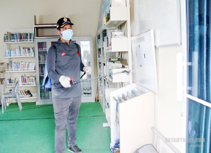 Bupati Bintan Apri Sujadi saat menyemprotkan cairan disinfektan ke salah satu area perkantoran pemerintah di Bintan